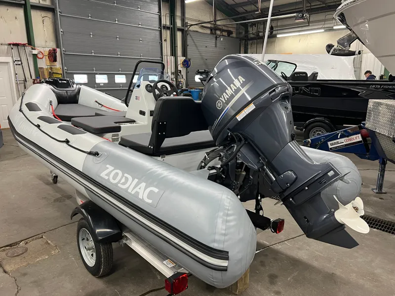 Slide: The Image of 2023 Zodiac Open 4.2 inflatable boat with Yamaha outboard motor in a garage setting. - 3