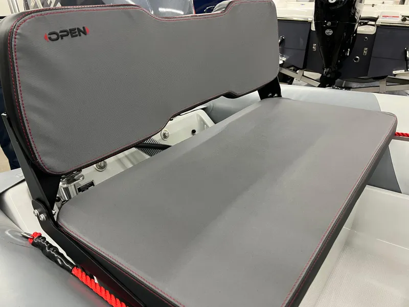 Slide: The Image of 2023 Zodiac Open 4.2 boat seat with gray upholstery and red accents. - 4