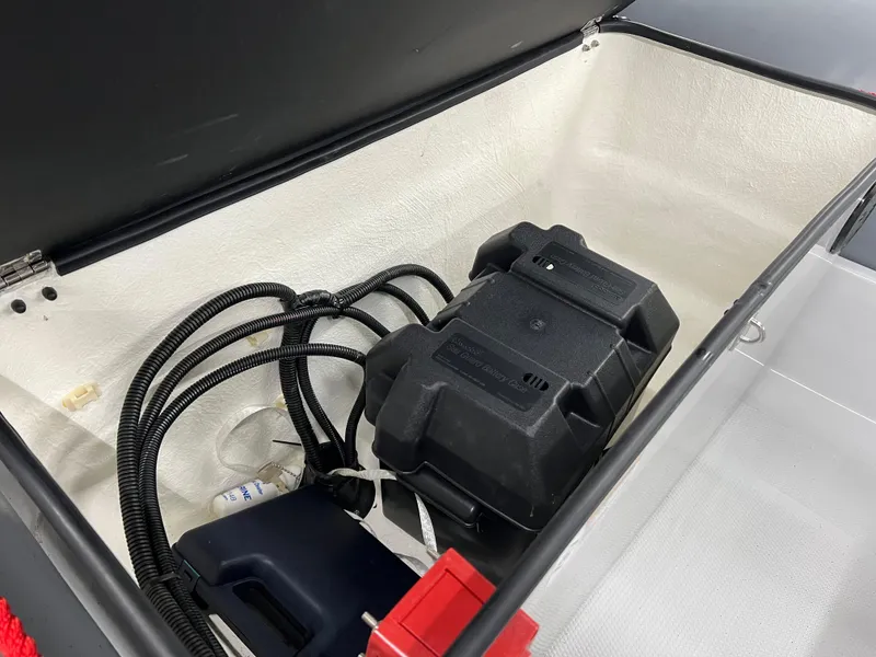 Slide: The Image of 2023 Zodiac Open 4.2 storage compartment with battery and wiring. - 5