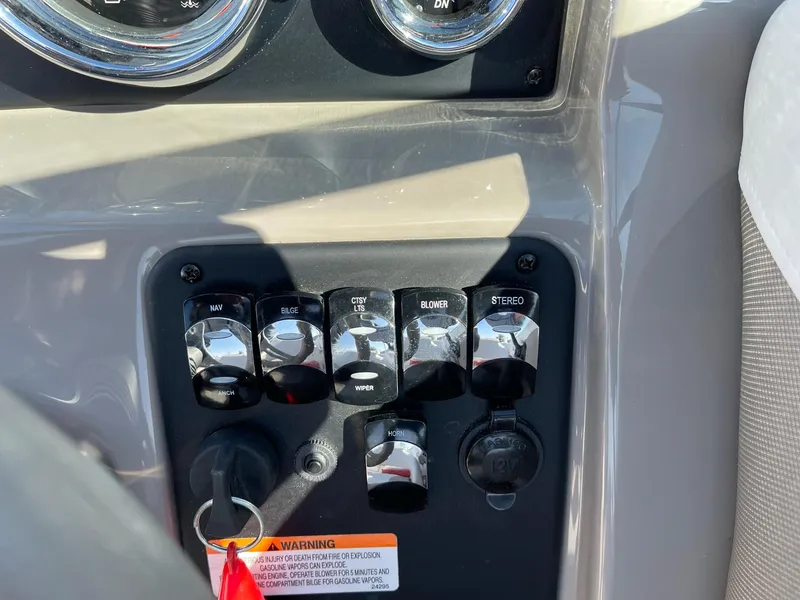 Slide: The Image of Control panel of a 2020 Crownline 205 SS boat with switches and key. - 14