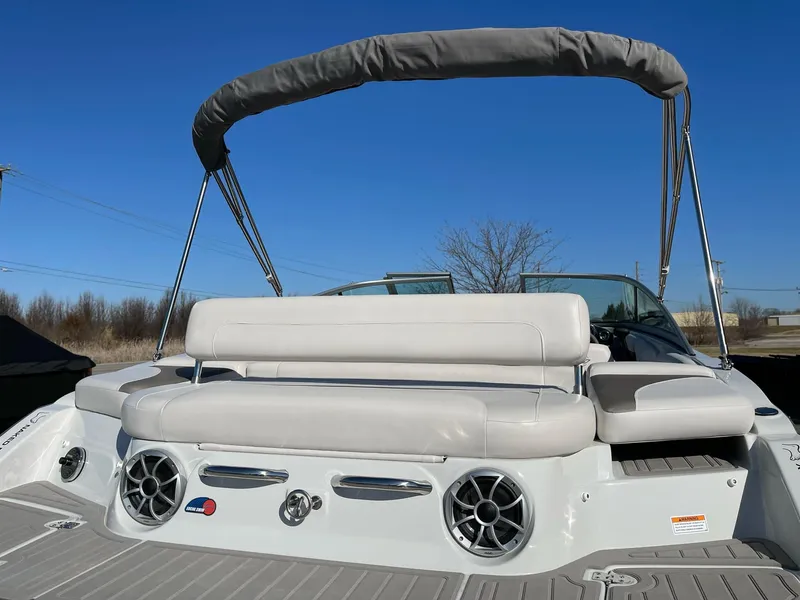Slide: The Image of 2020 Crownline 205 SS boat with beige seating and speakers, under a clear blue sky. - 4