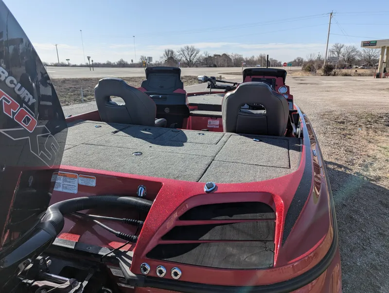 Slide: The Image of 2023 Nitro Z20 boat with red exterior, spacious seating, and Mercury engine, parked outdoors. - 6