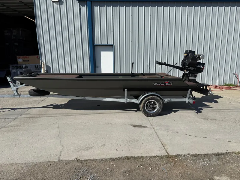 Slide: The Image of 2025 Gator Tail 1748 Gator Series boat on trailer, parked outside metal building. - 1