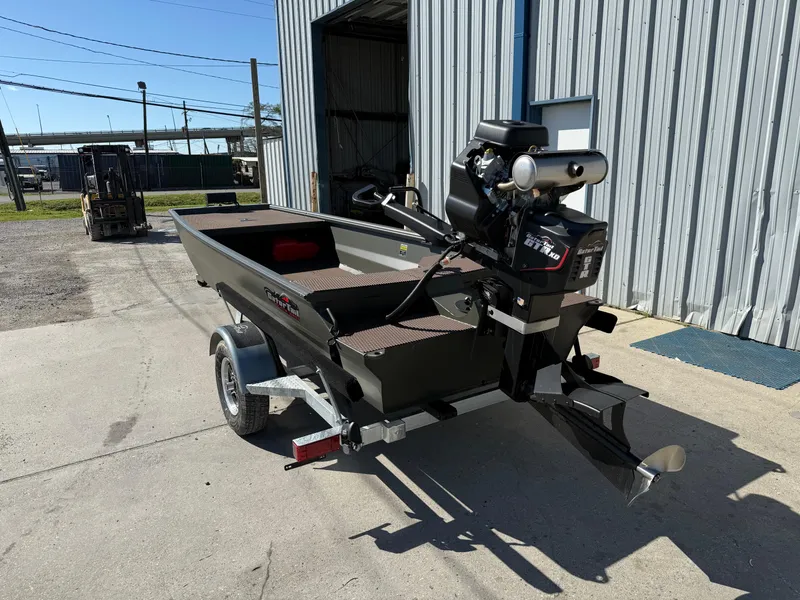 Slide: The Image of 2025 Gator Tail 1748 Gator Series boat on trailer, parked outside metal building. - 2