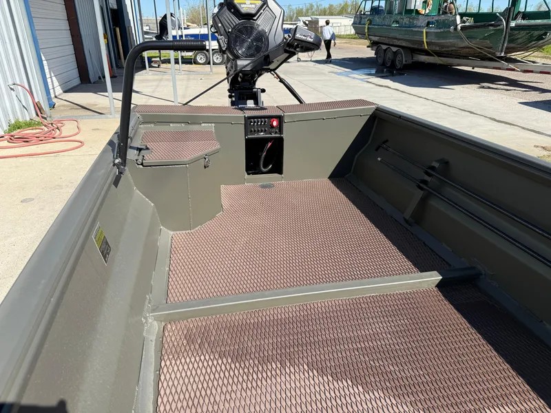 Slide: The Image of 2025 Gator Tail 1748 Gator Series boat with open deck and motor, parked outdoors. - 4