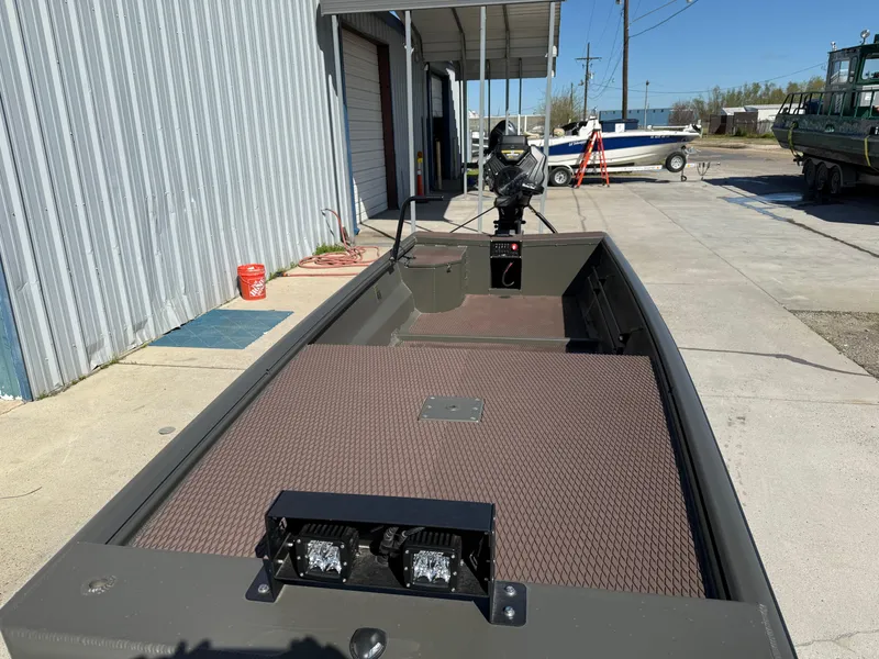 Slide: The Image of 2025 Gator Tail 1748 Gator Series boat, parked outdoors, showcasing deck and motor. - 8