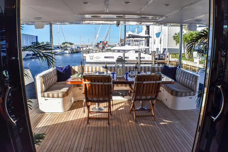 Slide: The Image of Luxurious yacht deck dining area with striped seating, wooden table, and marina view. Johnson Country Kitchen 2006. - 5