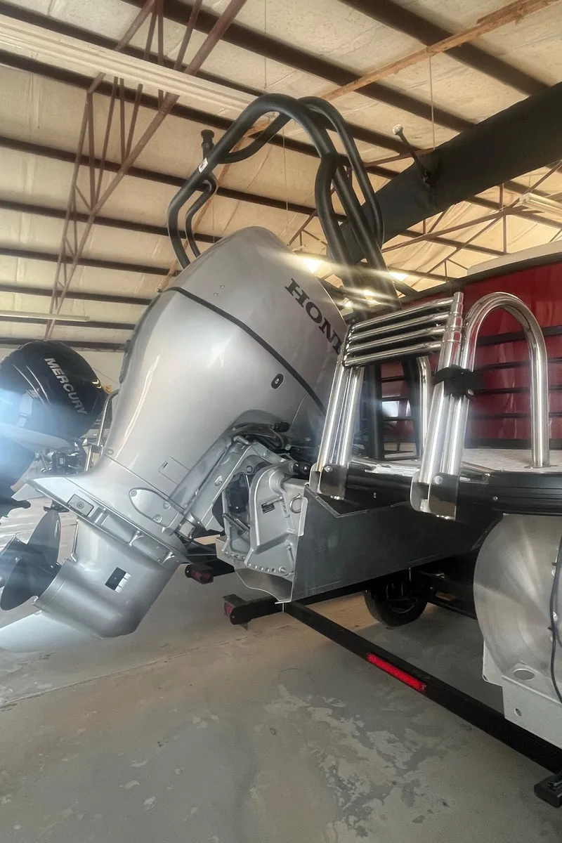 Slide: The Image of 2022 Xcursion 223 RFX boat with Honda outboard motor in a warehouse. - 12