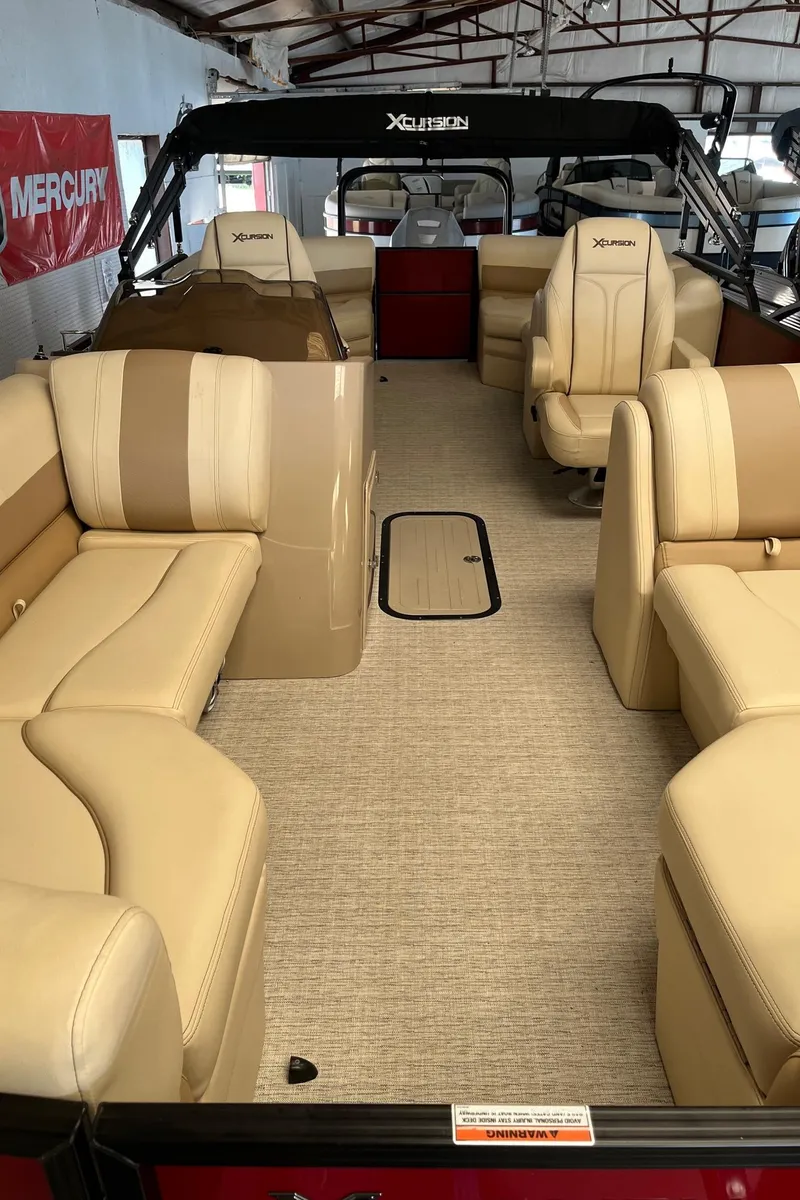 Slide: The Image of 2022 Xcursion 223 RFX boat interior with beige seating and carpeted floor. - 4