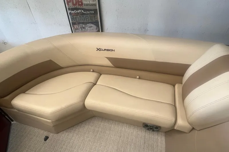 Slide: The Image of 2022 Xcursion 223 RFX boat interior with beige seating and logo. - 5