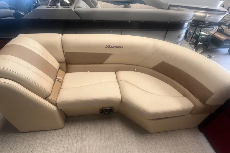 Slide: The Image of 2022 Xcursion 223 RFX boat seating, beige and brown upholstery, indoor showroom display. - 6