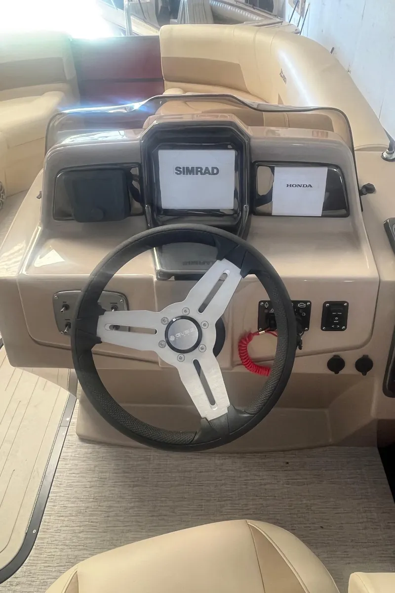 Slide: The Image of 2022 Xcursion 223 RFX boat dashboard with steering wheel and Simrad display. - 9
