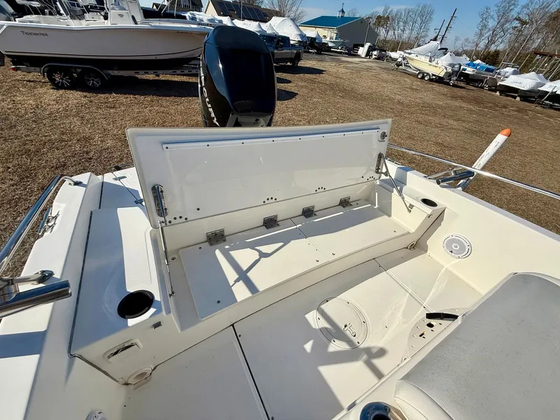 Slide: The Image of 2016 Boston Whaler 240 Dauntless boat interior with open storage compartment, parked outdoors. - 18
