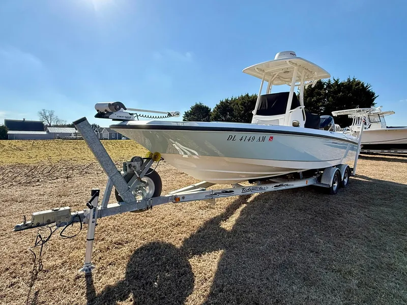 Slide: The Image of 2016 Boston Whaler 240 Dauntless boat on trailer, parked on grass under clear sky. - 3
