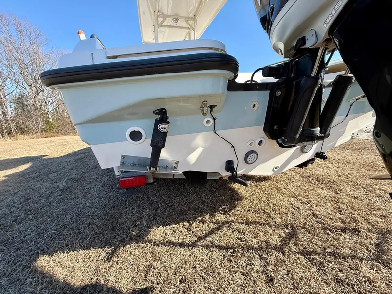 Slide: The Image of 2016 Boston Whaler 240 Dauntless boat stern on grass, showcasing hull and motor mount. - 30