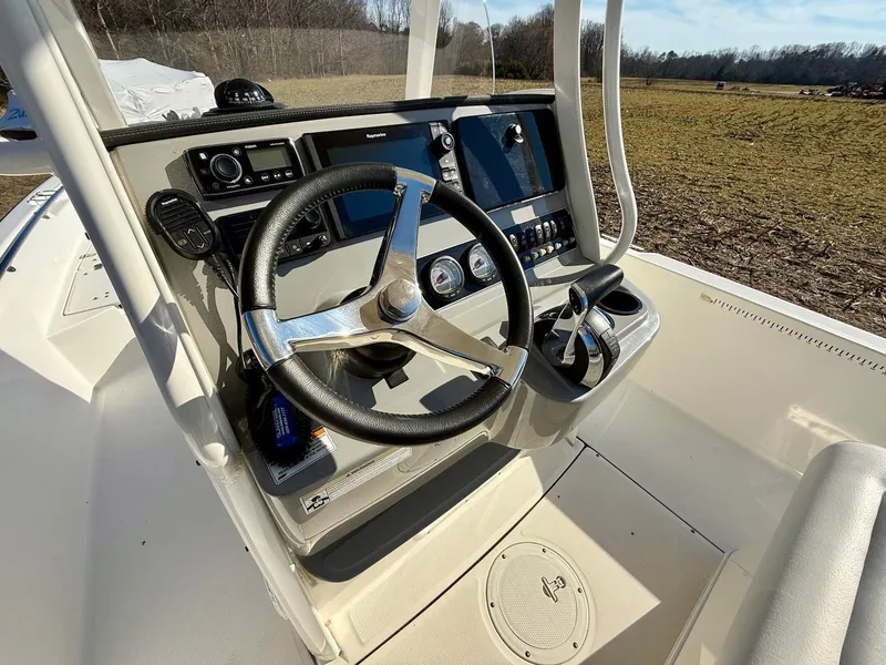 Slide: The Image of 2016 Boston Whaler 240 Dauntless boat console with steering wheel and navigation controls. - 5