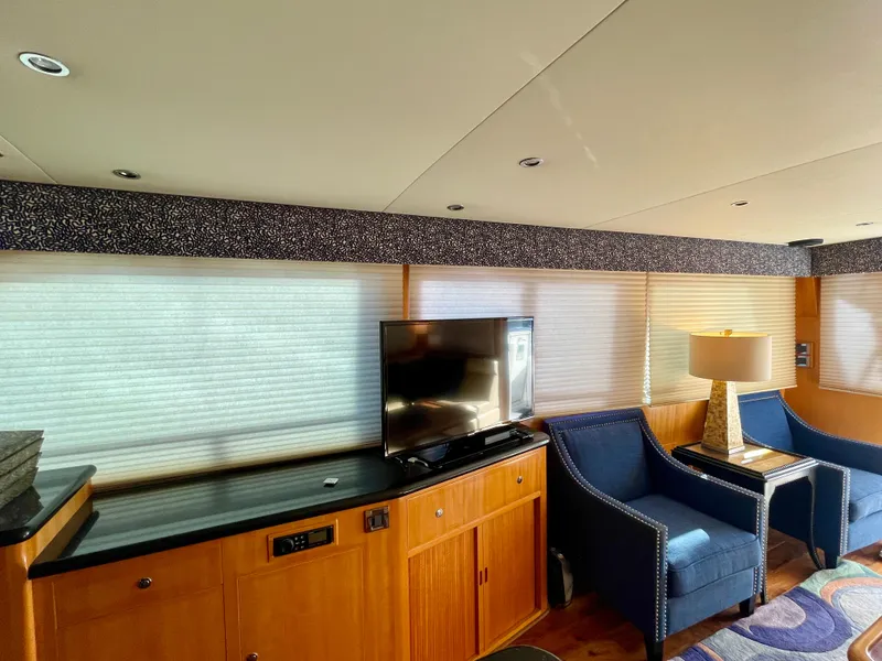 Slide: The Image of Interior of 2003 Ocean Alexander 510 Classico yacht with TV, blue chairs, and wooden cabinetry. - 33