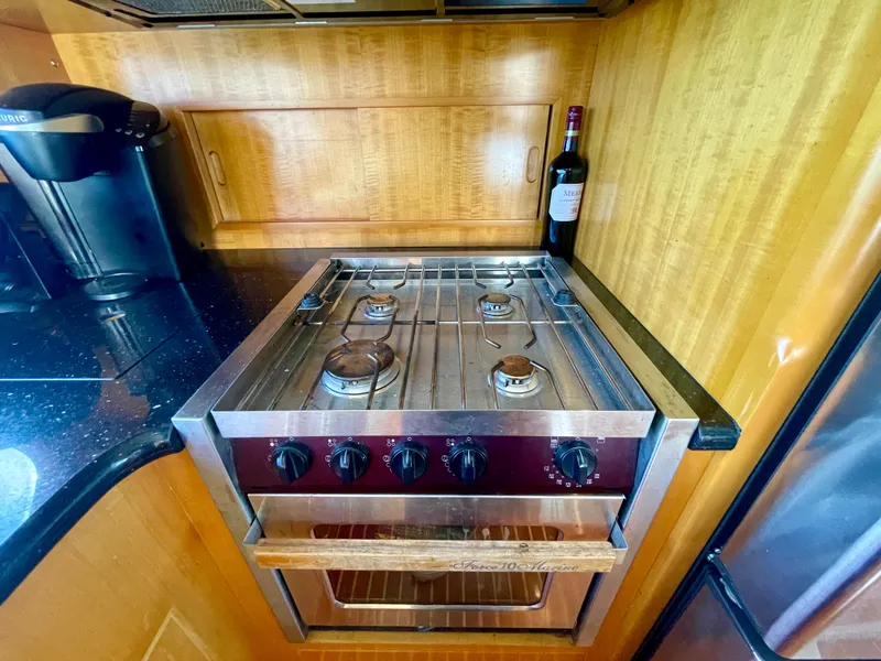 Slide: The Image of Galley kitchen in 2003 Ocean Alexander 510 Classico yacht with stove and wine bottle. - 44