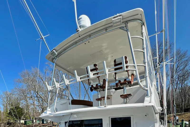 Slide: The Image of 1999 Viking 55 yacht with upper deck and fishing chairs, clear blue sky background. - 16