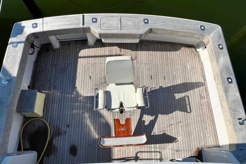 Slide: The Image of 1999 Viking 55 boat deck with central fishing chair and wooden flooring. - 17