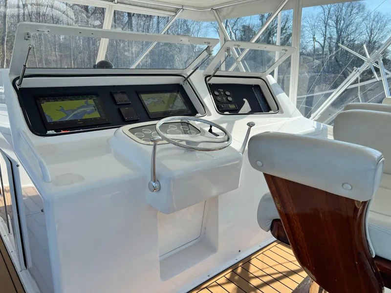 Slide: The Image of 1999 Viking 55 yacht helm with modern navigation controls and wooden captain's chair. - 20