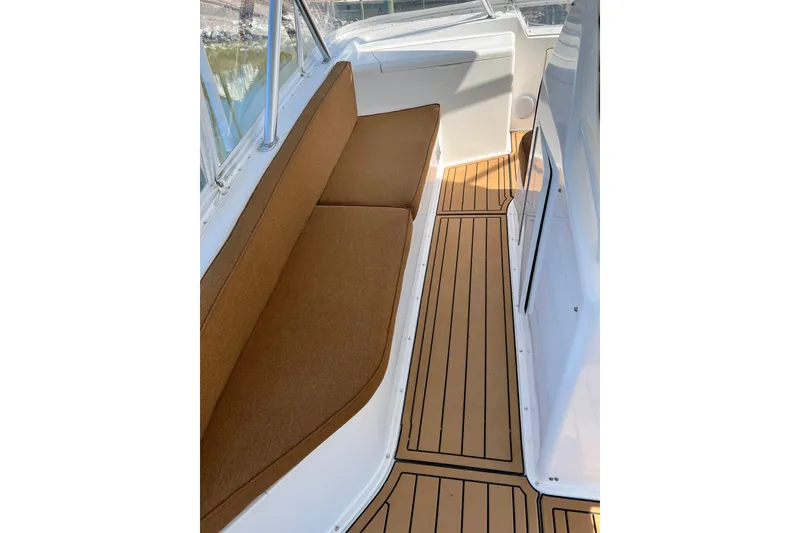 Slide: The Image of 1999 Viking 55 boat interior with brown cushioned seating and wooden flooring. - 23