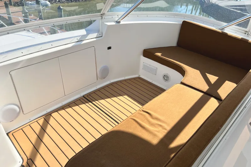 Slide: The Image of 1999 Viking 55 yacht interior with brown seating and wooden flooring. - 24