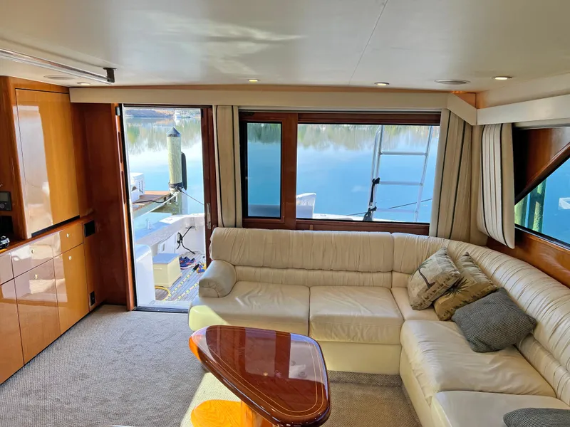 Slide: The Image of Luxurious interior of a 1999 Viking 55 yacht with cream leather seating and wooden accents. - 28