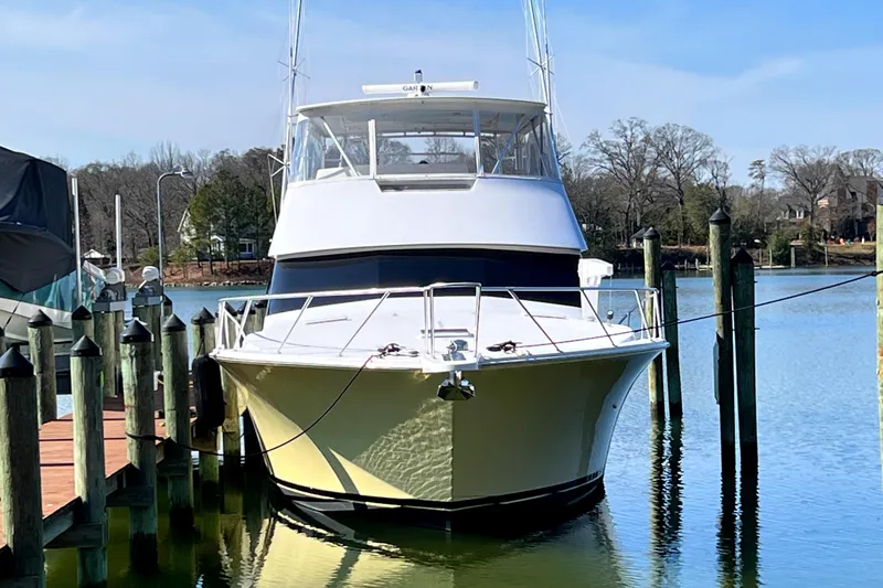 Slide: The Image of 1999 Viking 55 yacht docked in a serene marina setting. - 3