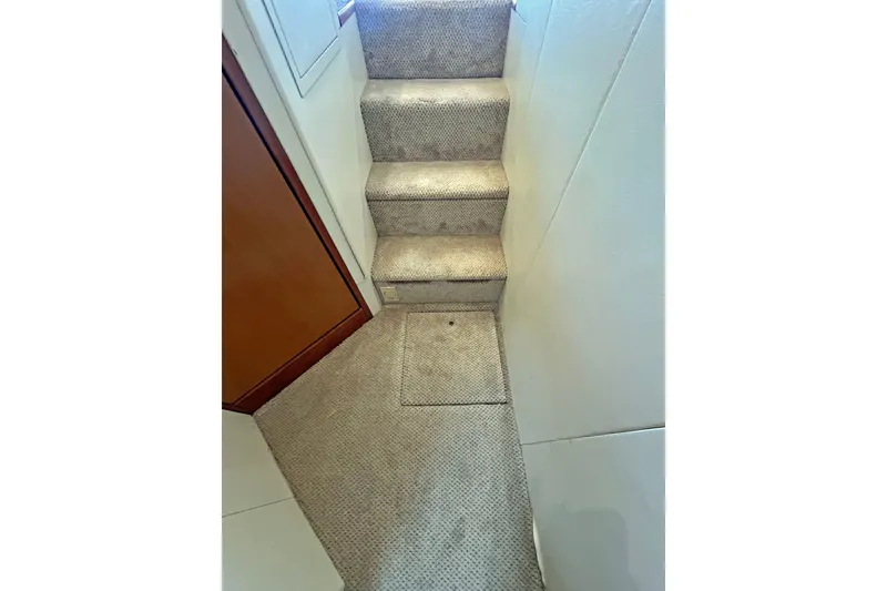 Slide: The Image of Carpeted stairs inside a 1999 Viking 55 yacht. - 34
