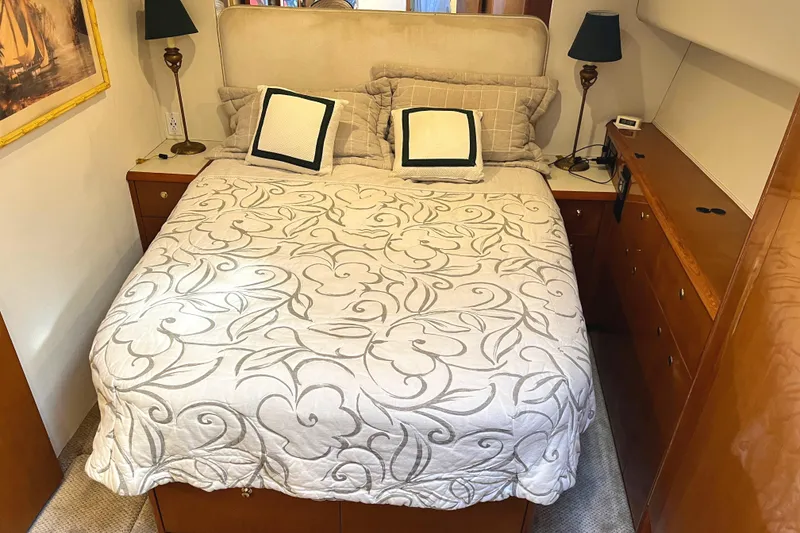 Slide: The Image of Cozy bedroom interior on a 1999 Viking 55 yacht with elegant bedding and wooden furnishings. - 40