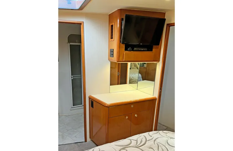 Slide: The Image of 1999 Viking 55 interior with TV, wooden cabinetry, and mirrored wall. - 42