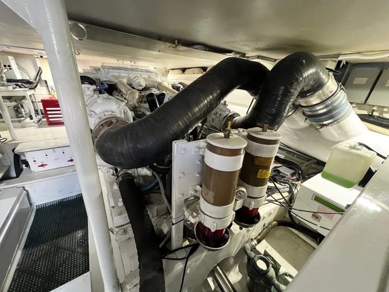 Slide: The Image of Engine room of a 1999 Viking 55 yacht, showcasing mechanical components and filters. - 48