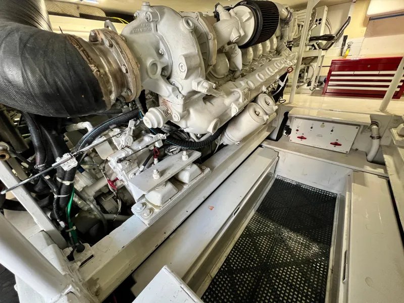 Slide: The Image of Engine room of a 1999 Viking 55 yacht, showcasing detailed machinery components. - 49