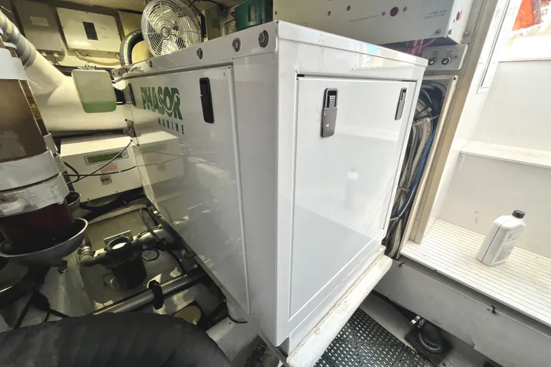 Slide: The Image of Engine room of a 1999 Viking 55 yacht with a white enclosure. - 54