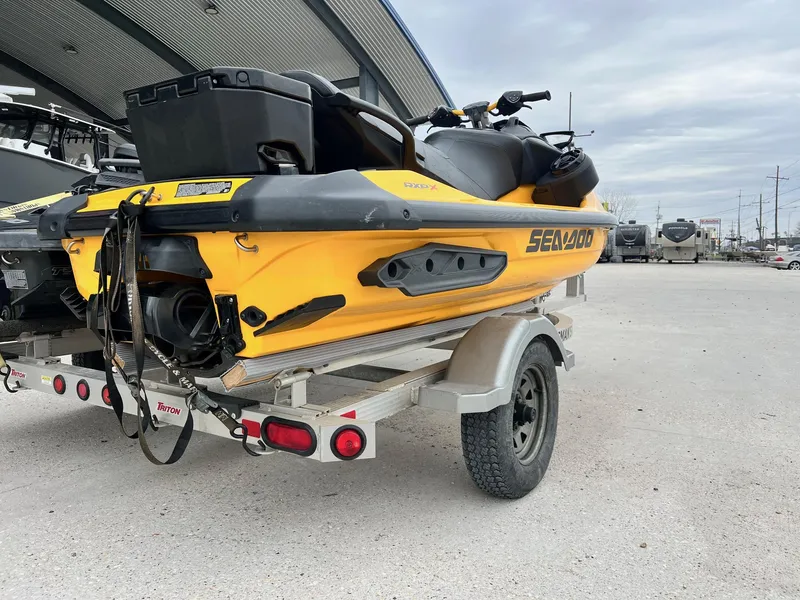 Slide: The Image of 2021 Sea-Doo RXP-X 300 jet ski on trailer, parked outdoors. - 3