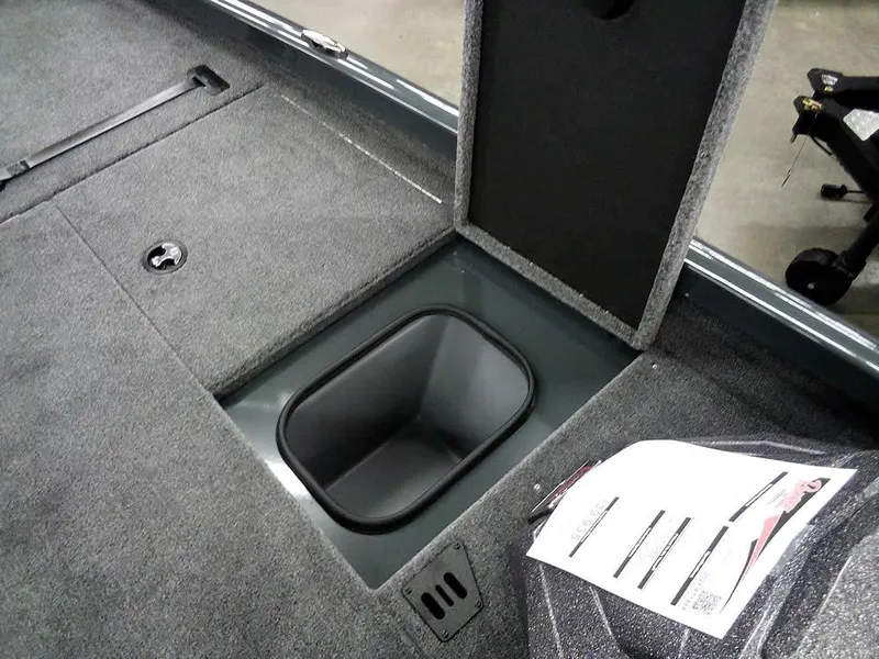Slide: The Image of 2025 Ranger RT188P boat storage compartment with open lid and carpeted interior. - 13