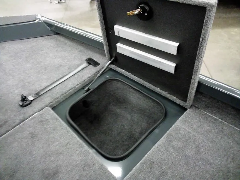 Slide: The Image of 2025 Ranger RT188P boat storage compartment with carpeted interior and secure latch. - 14