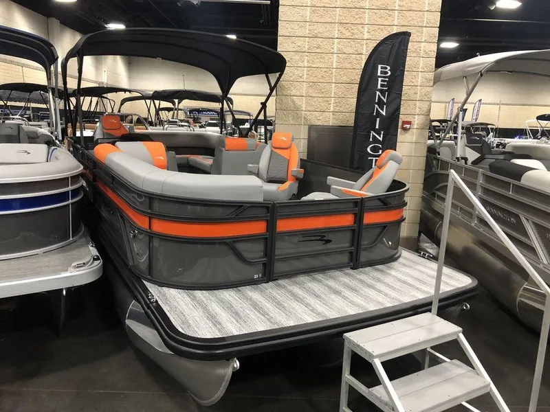 The Image of 2025 Bennington S L-Bench 23 SL pontoon boat with orange and gray seating on display. - 1