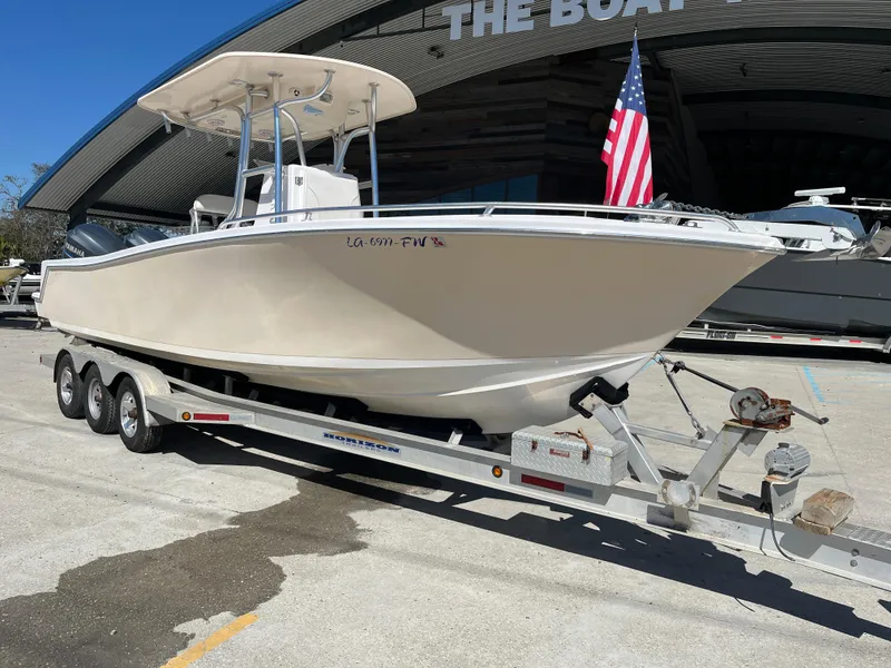 Slide: The Image of 2009 Ocean Runner 29 cc boat on trailer with American flag, parked outside. - 2