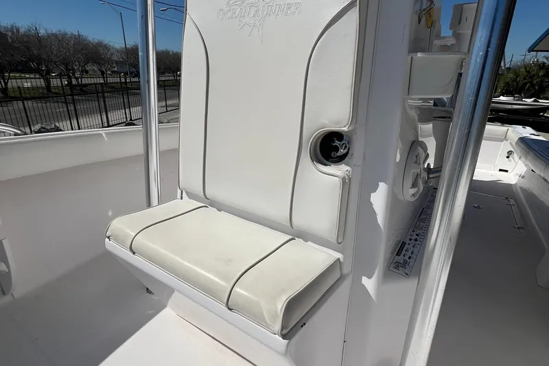 Slide: The Image of 2009 Ocean Runner 29 cc boat seat with white upholstery and storage compartment. - 21