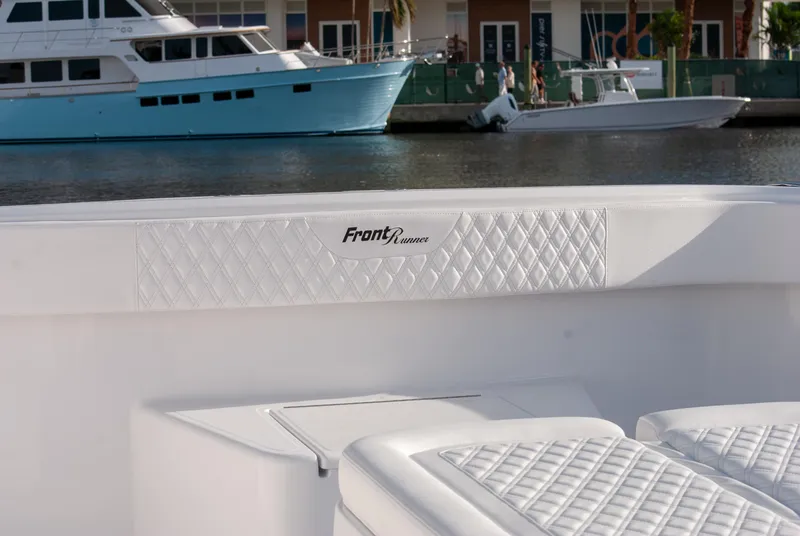Slide: The Image of Front Runner 43 Catamaran 2025, white interior with quilted seating, docked near waterfront. - 31