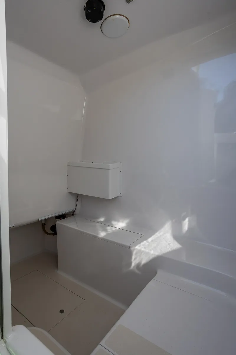 Slide: The Image of Interior of 2005 French Yachts 34 Center Console, featuring sleek white design and compact layout. - 13