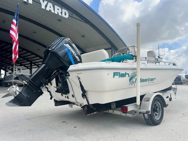 Slide: The Image of 2001 Fishmaster 19 CC boat with Mercury outboard motor, parked at a boatyard. - 2