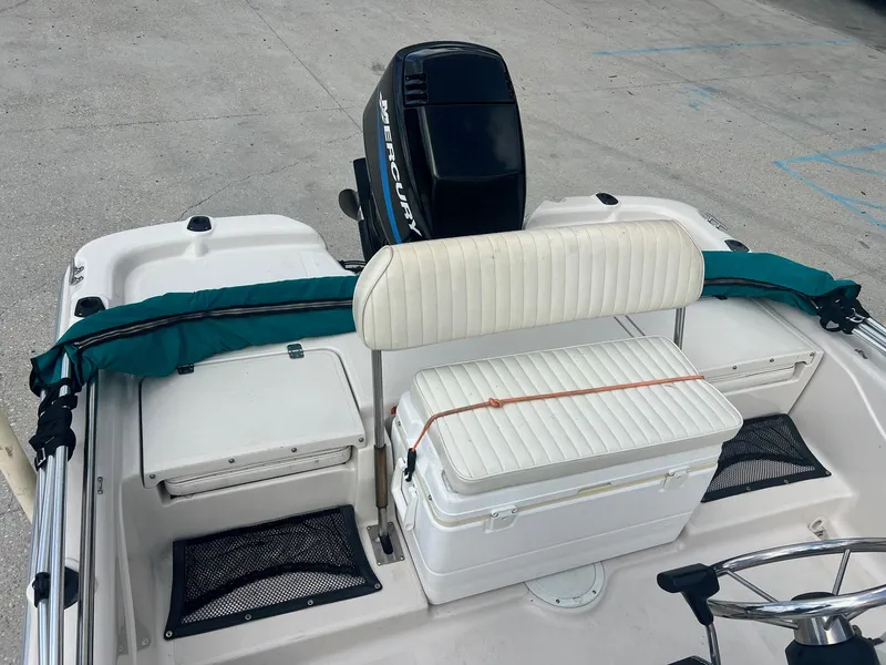 Slide: The Image of 2001 Fishmaster 19 CC boat interior with seating, storage, and Mercury outboard motor. - 3