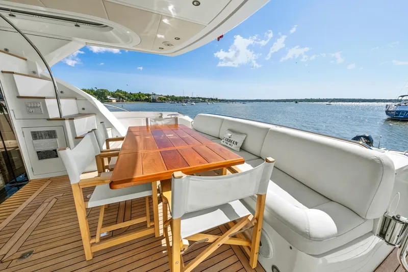 Slide: The Image of Luxurious Sunseeker Manhattan 65 yacht deck with seating, table, and scenic water view. - 48