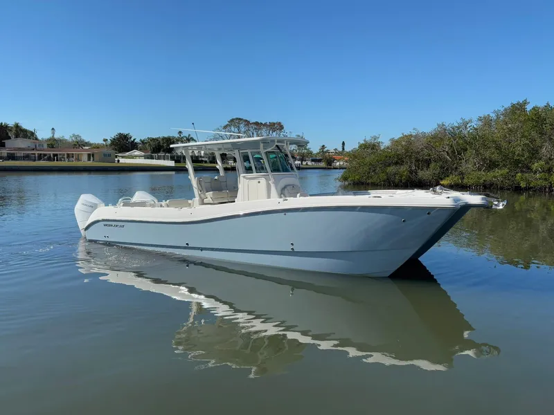 The Image of 2025 World Cat 325 CC boat on calm water, clear sky background. - 0