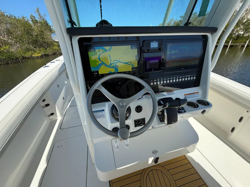 Slide: The Image of 2025 World Cat 325 CC boat cockpit with advanced navigation system and steering wheel. - 11