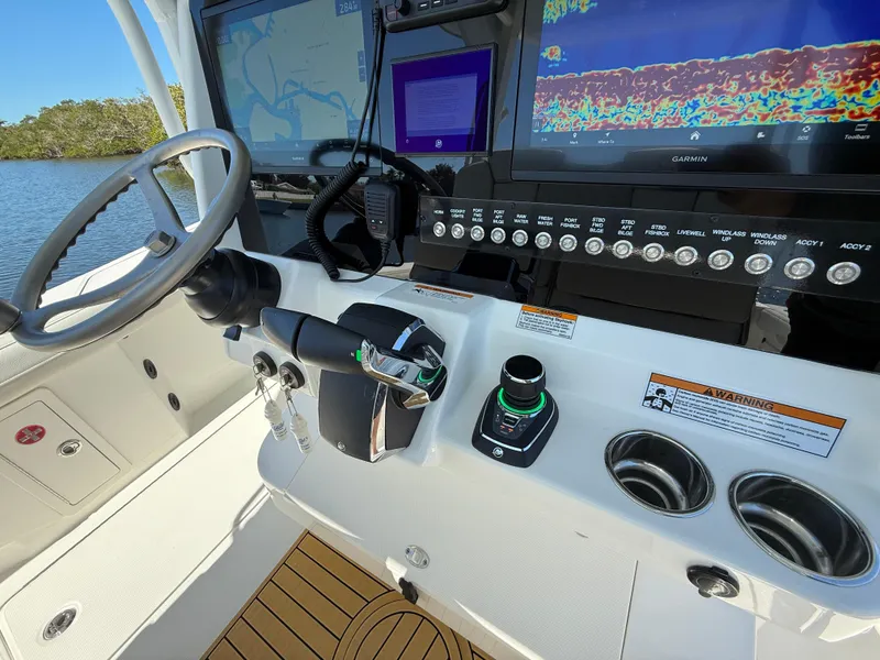 Slide: The Image of Cockpit of 2025 World Cat 325 CC boat with navigation screens and controls. - 13