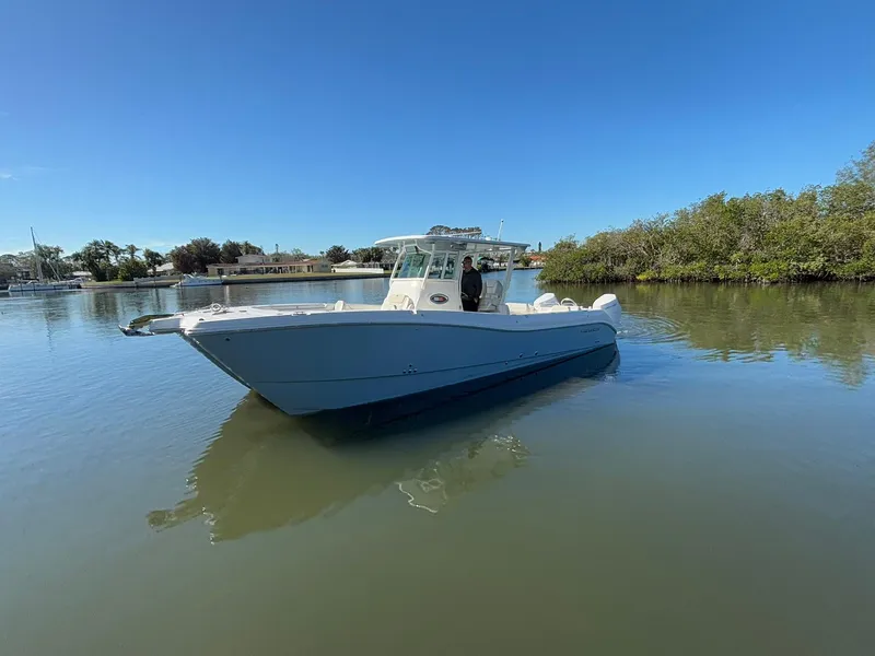 Slide: The Image of 2025 World Cat 325 CC boat on calm water, clear sky background. - 3